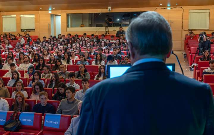 Julio Ancochea, presidente de Asomega, inaugura la jornada "Trayectoria y vida" ante una sala repleta de estudiantes de Medicina.