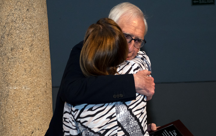 El presidente de honor de Asomega, Aniceto Charro, abraza a Delia Cerviño al entregarle su placa.