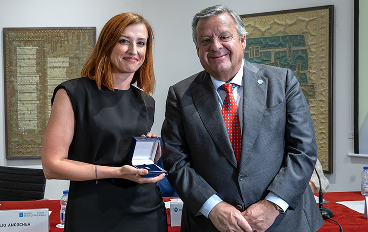 Eva Poveda muestra la Insignia de Oro de Asomega que acaba de recibir de manos de Julio Ancochea.