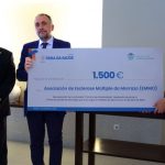 Julio Ancochea, a la izquierda, con el conselleiro de Sanidade, Julio García Comesaña, que hace entrega del cheque de Asomega Axuda a Leo Rodríguez, presidenta de EMMO