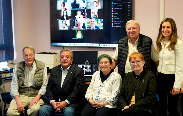 Algunos de los asistentes presenciales y, en la pantalla, los conectados online.