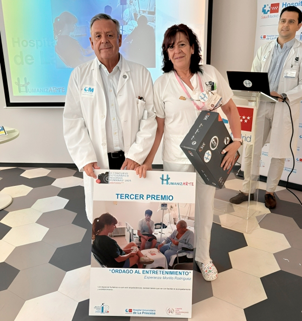 Julio Ancochea entrega a la enfermera Esperanza Morillo Rodríguez el tercer premio por su fotografía "Órdago al entretenimiento".
