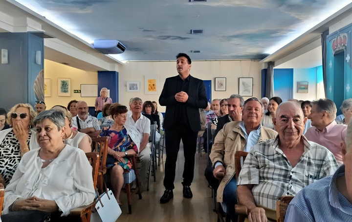 Manoele de Felisa durante a súa actuación. Á dereita entre o público, diante do cantautor, o presidente de Asomega, Julio Ancochea.
